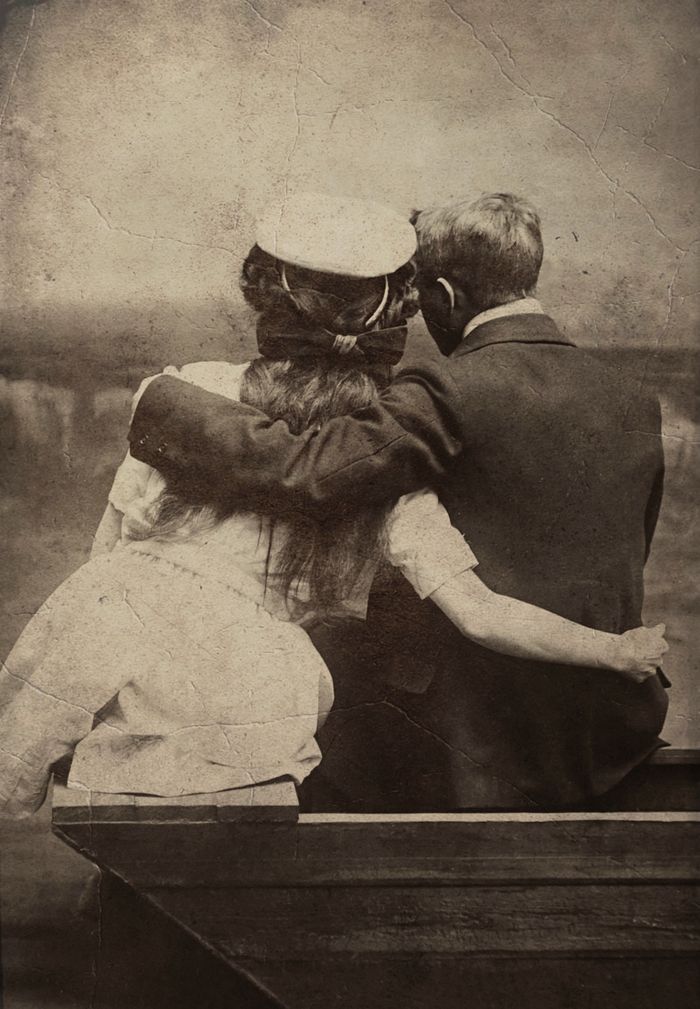 Vintage sepia photograph of a couple sitting together, embracing in a nostalgic setting.